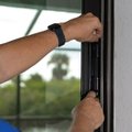 Installer working on the lock of a sliding glass door